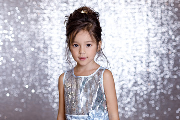 cute smiling little child girl in silver and blue dress