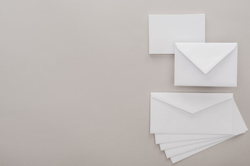 top view of white envelopes on grey background with copy space