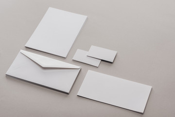  Envelope, cards and sheets of paper on grey background