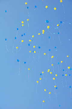 Blue And Yellow Balloons Against A Blue Sky