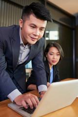 Young Vietnamese business team reading important e-mail from investor