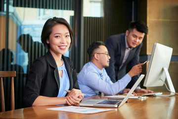 Portrait of smiling beautiful Asian businesswoman working in office