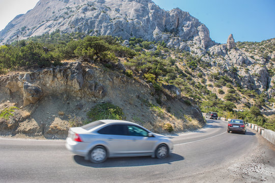 Fototapeta Cars Moves along a winding road in the mountains