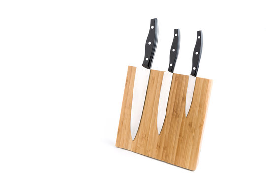 Wooden knife holder with three different types of knifes on white background.