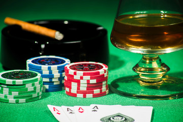 The concept of gambling, cards and chips with a glass of cognac and a cigar