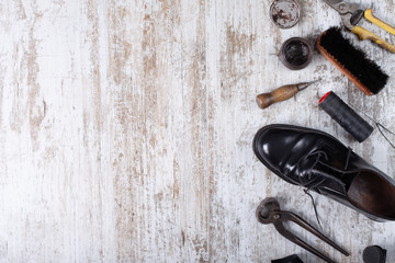 Tools for shoe repair on wood background