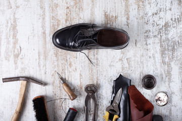 Tools for shoe repair on wood background