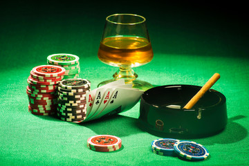 The concept of gambling, cards and chips with a glass of cognac and a cigar