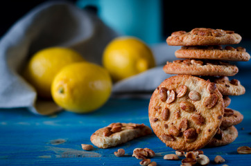 Round orange biscuits with colorful candied fruits and a slice of juicy orange lying on a wooden table