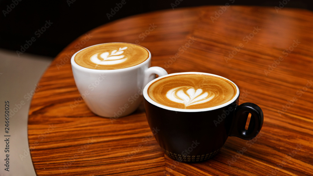 Wall mural two cups of cappuccino coffee on a wooden table