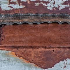 Rusty metal surface with nailed rubber tape