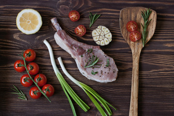 Raw fresh pork ribs with spices and rosemary, cherry tomatoes, garlic, hot pepper and salt on a...