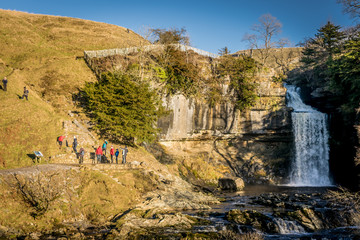 people enjoying the view of a waterfall in Yorkshire, England. 