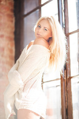 Beautiful and cute blonf girl posing for photo in the loft studio