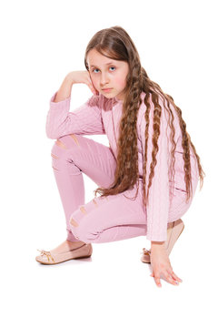 A girl of 10-11 years old with long beautiful hair sat on one knee. Isolation on a white background.