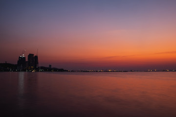 Fototapeta na wymiar colorful sunset over city and sea