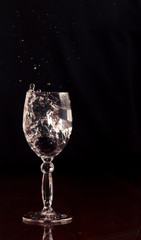 A glass of water with falling grapes