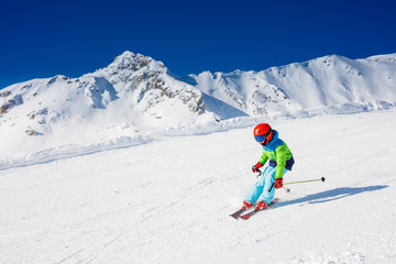 Cute skier boy in a winter ski resort.