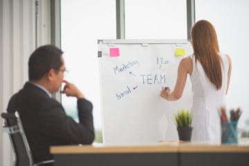 Successful business young woman presenting to employees, business coach giving presentation to clients in meeting room, team leader reporting about work explaining result on whiteboard