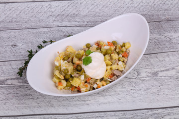 Traditional Russian salad with chicken in the white bowl