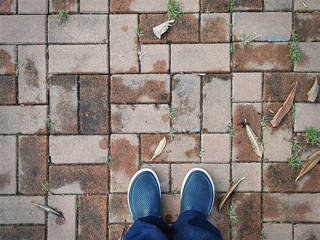 High Angle View of Man Wearing Rubber Shoes on Tiled Floor