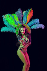 Beautiful young woman in carnival peacock costume. Beauty model woman at party over holiday...
