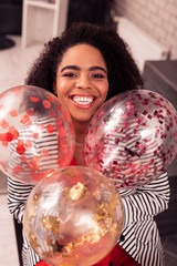 Fototapeta premium Happy positive woman holding beautiful colorful balloons