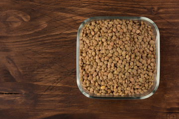Yellow lentil in a bowl on wooden background