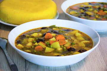 Vegetarian canary bean soup made of canary beans, celery, carrot, potato, tomato, leek, green onions garnished with parsley