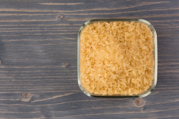 white rice in bowl on wooden table background