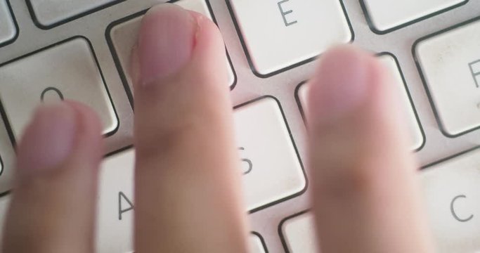 Close-up 4K shot of someone gaming on a Mac keyboard, repeatedly hitting the W A S D keys.
