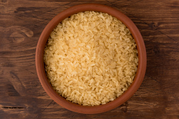 white rice in bowl on wooden table background
