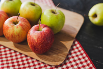 group of apples on wooden cutting board with napkin