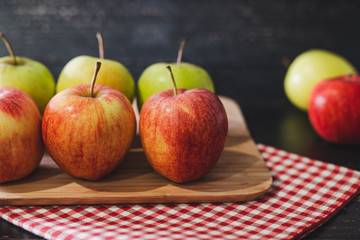 group of apples on wooden cutting board with napkin