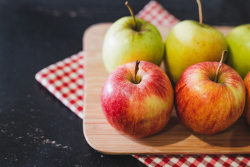 group of apples on wooden cutting board with napkin