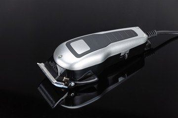 Close up of Hair Barber Clippers, Haircut accessories on the black mirror background with copy space.