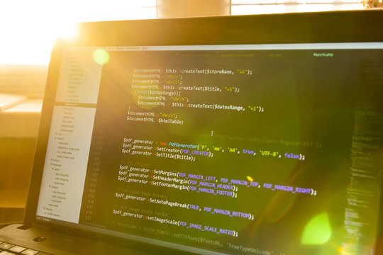 Modern software development background: nice looking laptop with programm on display.