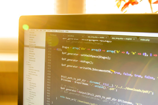 Modern software development background: nice looking laptop with programm on display.