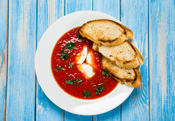 Tomato soup with mozzarella on white background