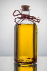 Una botella de cristal transparente con aceite aislada sobre fondo blanco.