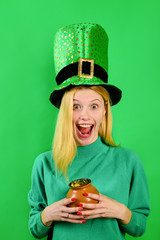 Saint Patrick's Day. Happy girl in green top hat holds pot with gold. Leprechaun. Irish Traditions....