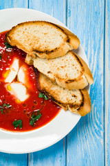 Tomato soup with mozzarella on white background