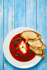 Tomato soup with mozzarella on white background