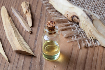 Obraz na płótnie Canvas A bottle of sandalwood essential oil with white sandalwood