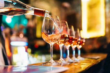 Service Serving Pouring Wine in shiny glasses in bar restaurant night club - obrazy, fototapety, plakaty
