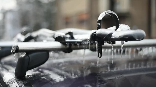Bicycle rack on a car covered in ice after frozen rain phenomenon 