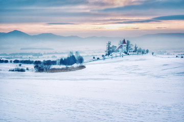 Europe, country Slovakia, region Turiec. Sunrise on winter landscape, beautiful church in the village of Abramova.