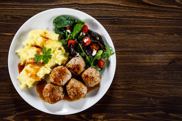 Roast meatballs with potatoes and vegetable salad