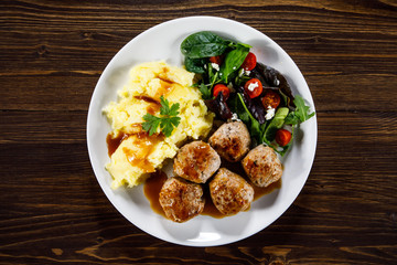 Roast meatballs with potatoes and vegetable salad