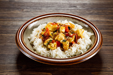 Grilled meat, white rice and vegetables on wooden table